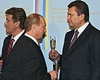 Неприемом Виктора Ющенко (идет налево) Владимир Путин сделал дружеский жест Виктору Януковичу (подходит справа). Фото: Дмитрий Азаров / Коммерсантъ.