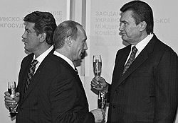 Неприемом Виктора Ющенко (идет налево) Владимир Путин сделал дружеский жест Виктору Януковичу (подходит справа). Фото: Дмитрий Азаров / Коммерсантъ.
